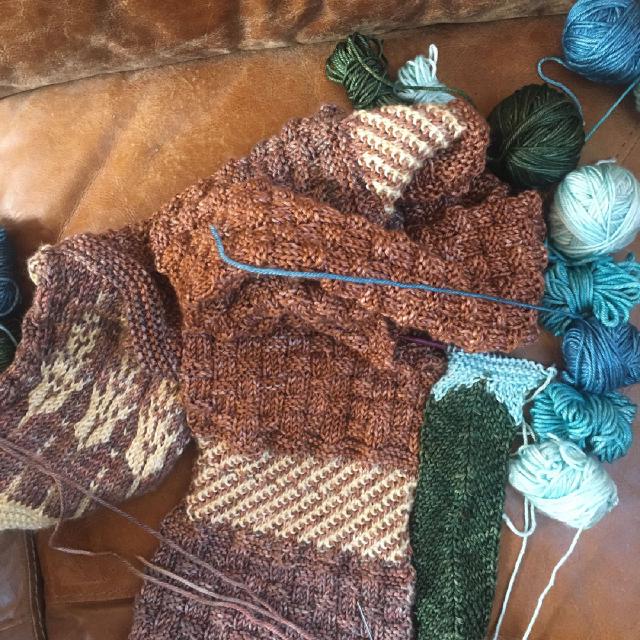 a work in progress a scarf and balls of yarn